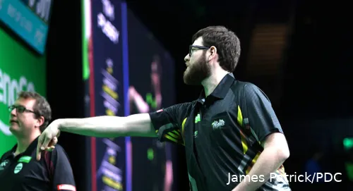 Tim Pusey throws a dart at the board