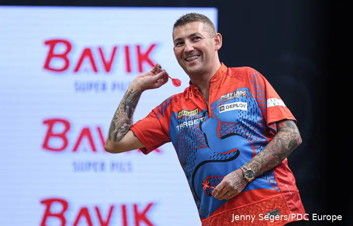 Nathan Aspinall lacht naar de zijkant van het podium