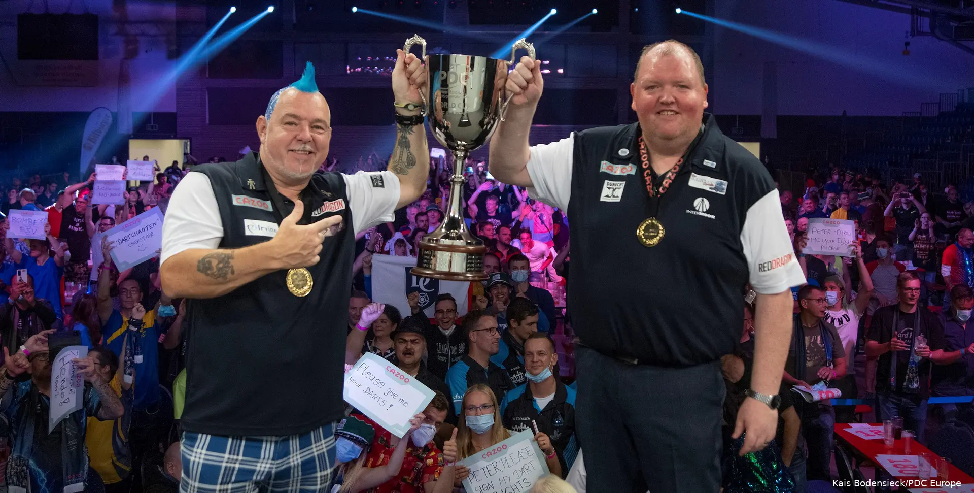 Peter Wright and John Henderson lift the World Cup trophy together.