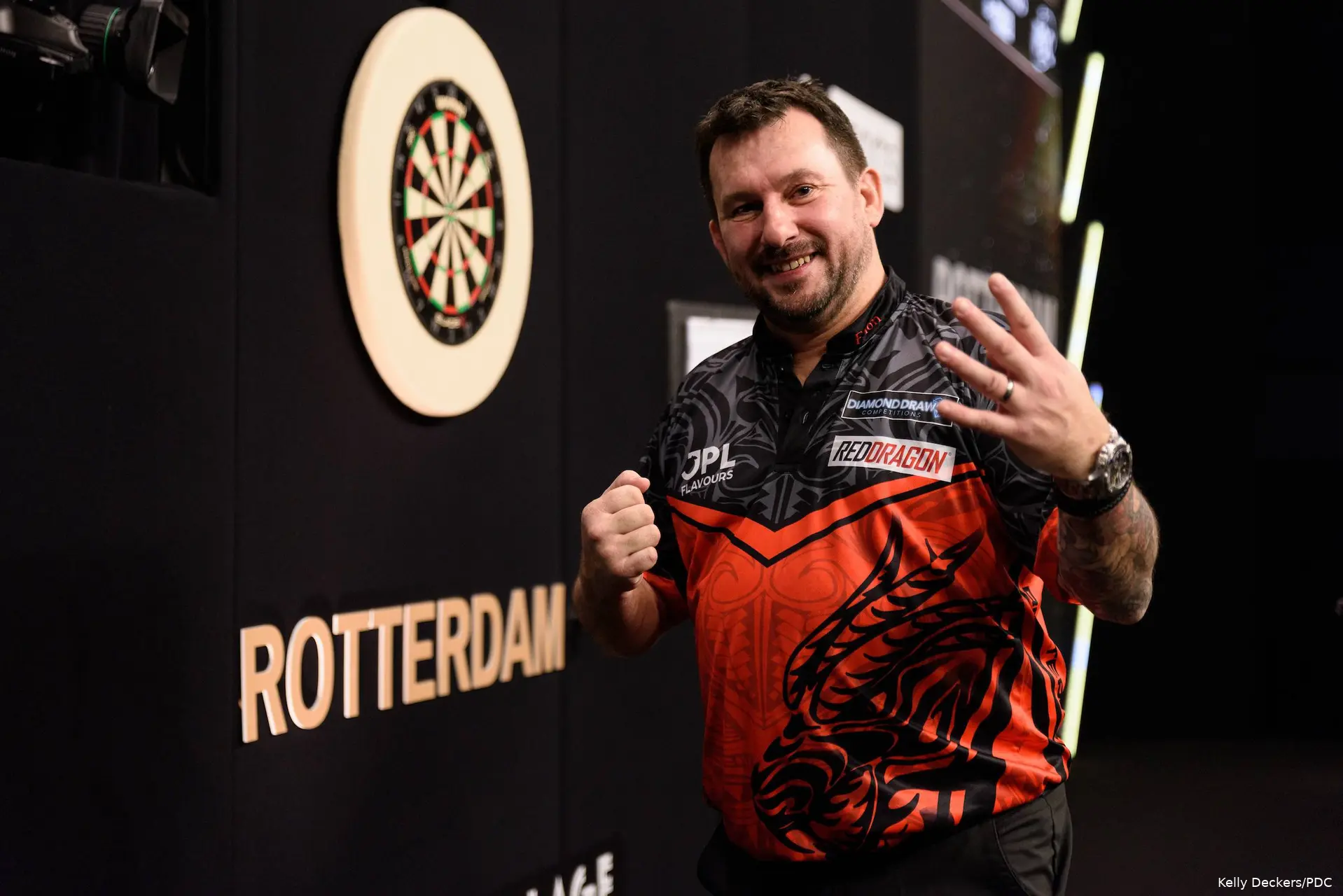 Jonny Clayton steekt vier vingers op naar de camera.