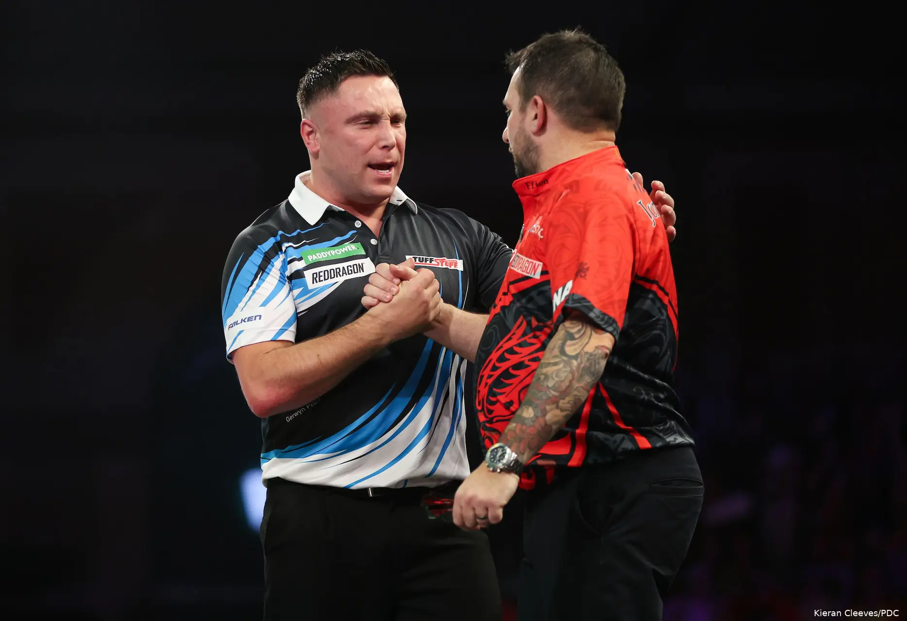 Gerwyn Price and Jonny Clayton shake hands on stage.