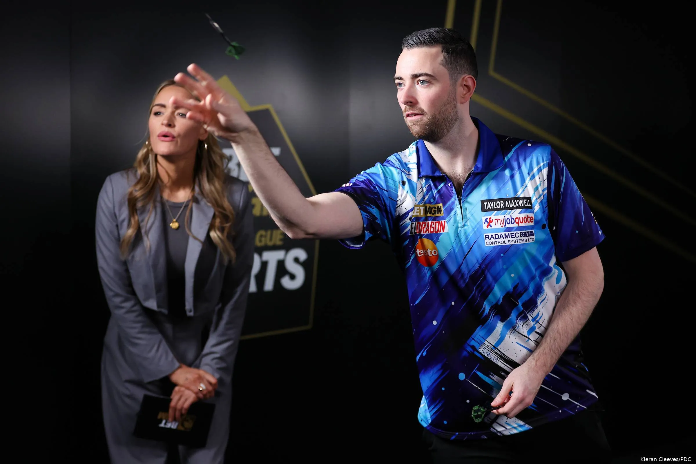 Luke Humphries takes on BetMGM's Eye of the Needle challenge as presenter Laura Woods watches on