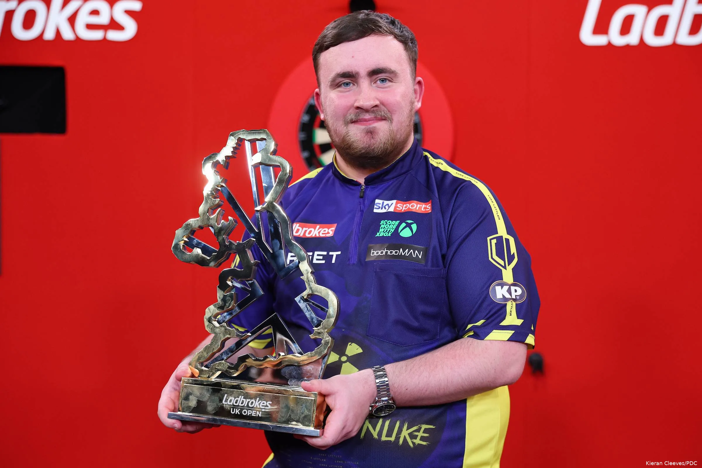 Luke Littler präsentiert den Pokal