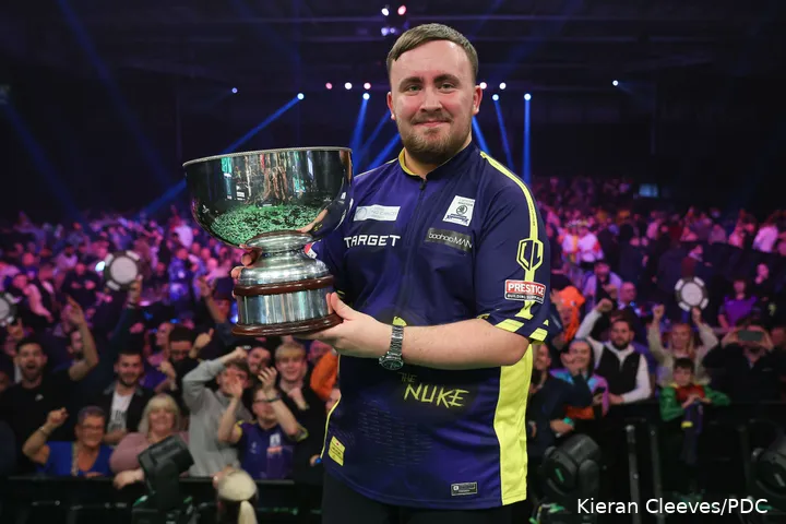 Luke Littler proudly poses with his Grand Slam trophy
