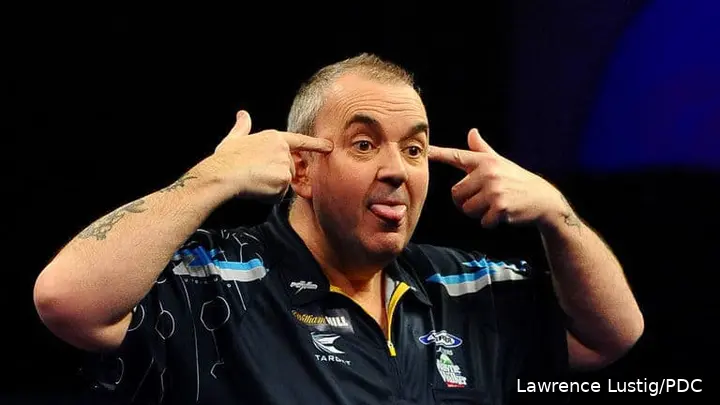 Phil Taylor points to his head with his fingers.