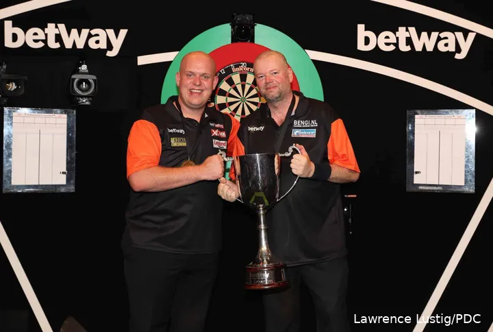Michael van Gerwen en Raymond van Barneveld houden de trofee omhoog na het winnen van de World Cup of Darts.