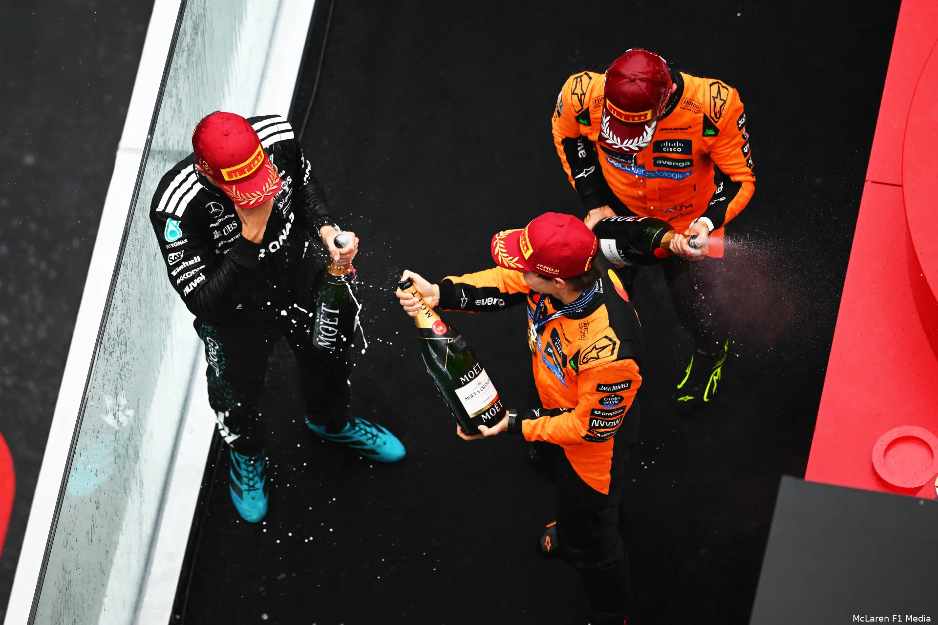 champagne podium george russell lando norris oscar piastri