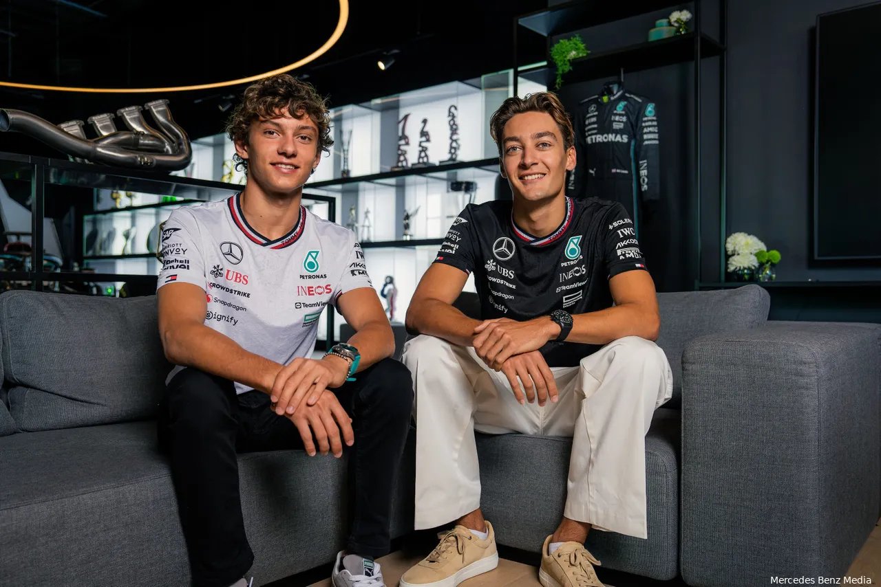 Mercedes 2025 drivers Andrea Kimi Antonelli and George Russell sitting together on a couch, smiling, in the Mercedes hospitality area.