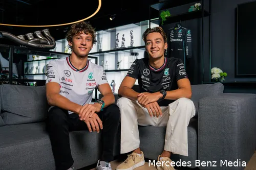 Mercedes 2025 drivers Andrea Kimi Antonelli and George Russell sitting together on a couch, smiling, in the Mercedes hospitality area.