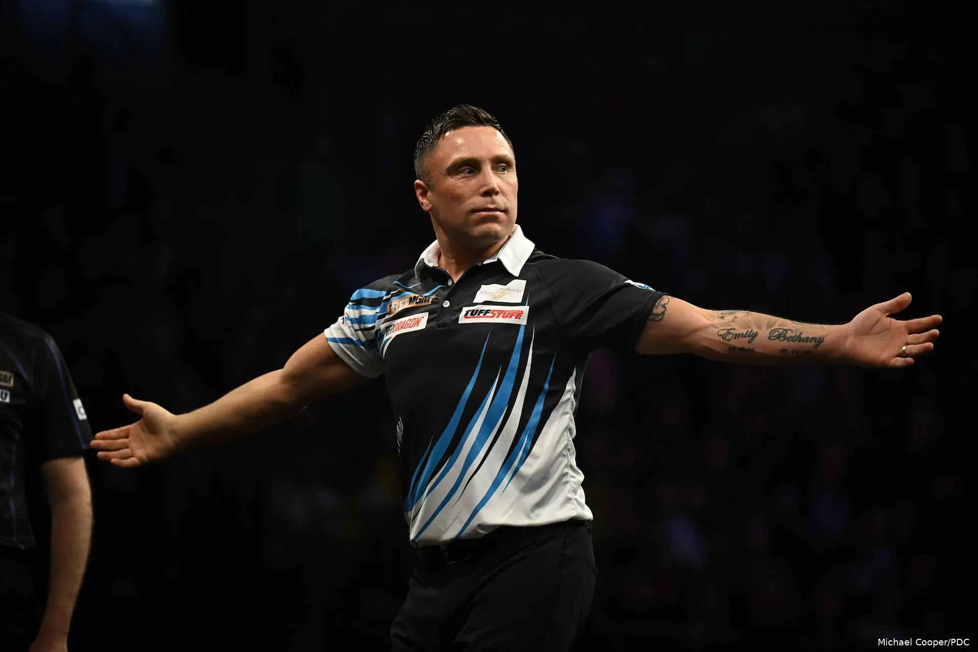 Gerwyn Price juicht met zijn armen wijdt richting het publiek.