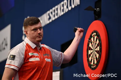 Niko Springer haalt zijn dartpijlen uit het dartbord