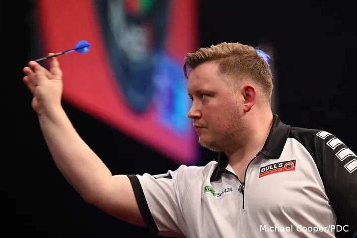 Martin Schindler throws his dart at a board.