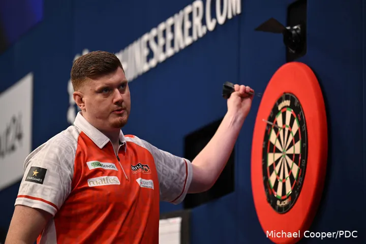 Niko Springer haalt zijn dartpijlen uit het dartbord