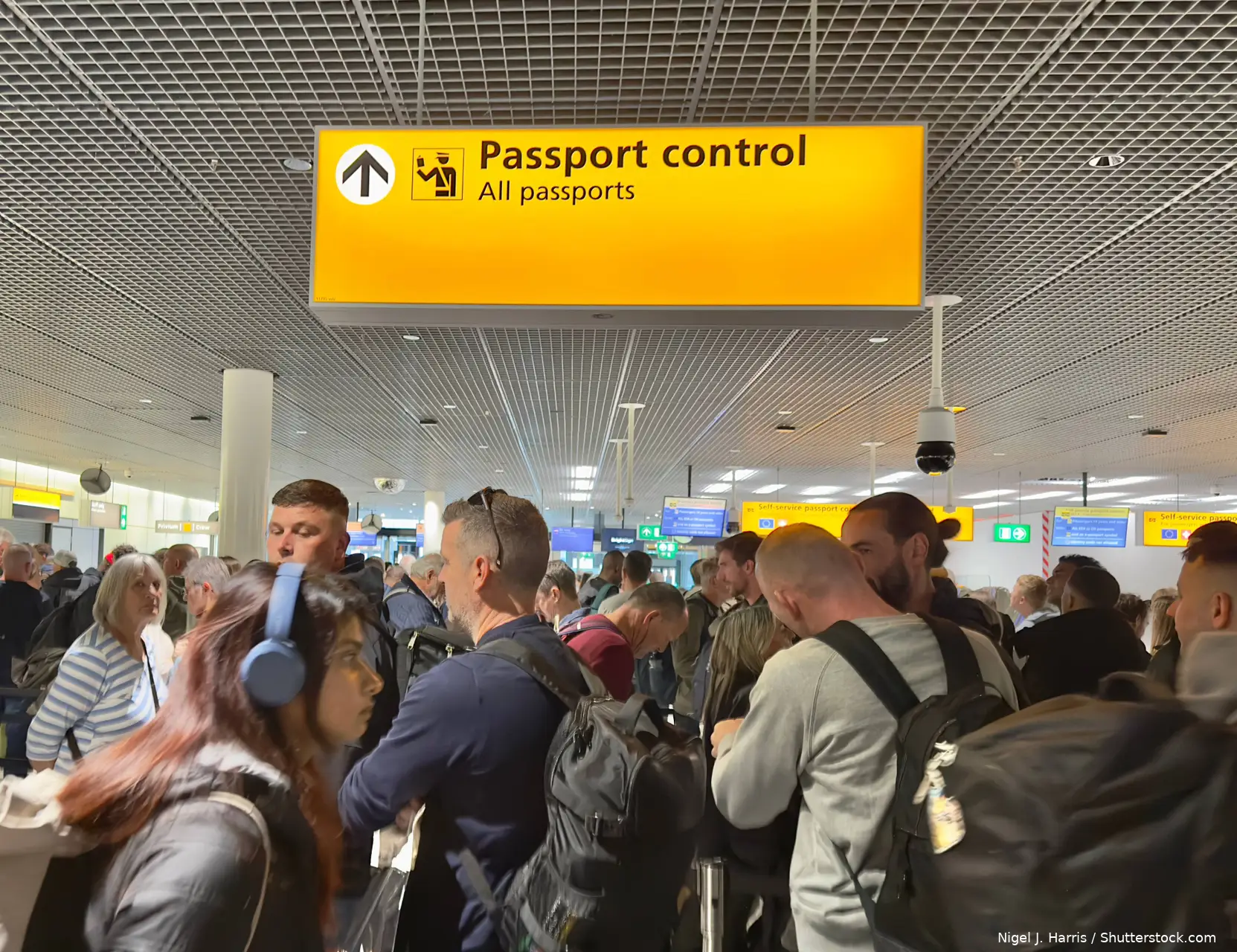 Lange rij reizigers bij de grenscontrole op Schiphol, over de wachttijden door het Europese EES-systeem