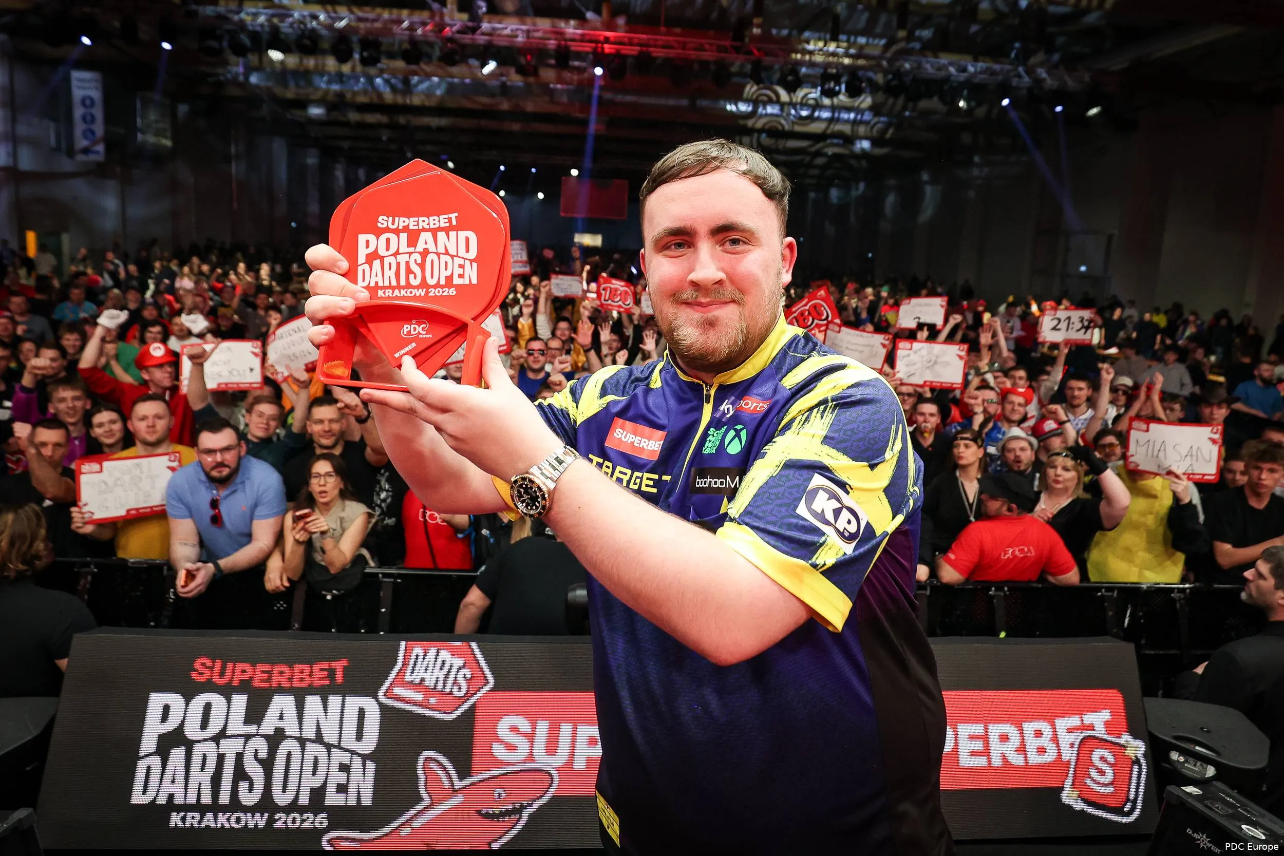 Luke Littler poseert trots met de trofee van de Poland Darts Open