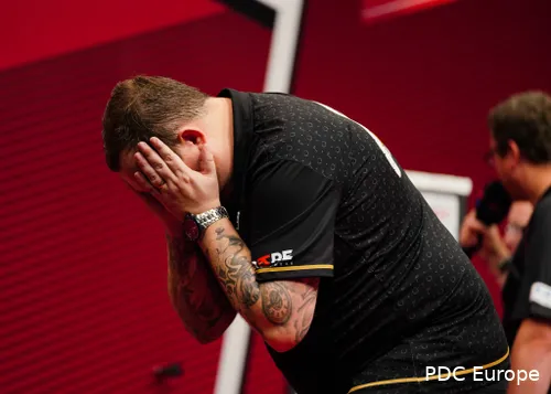 Huybrechts covers his face with his hands.