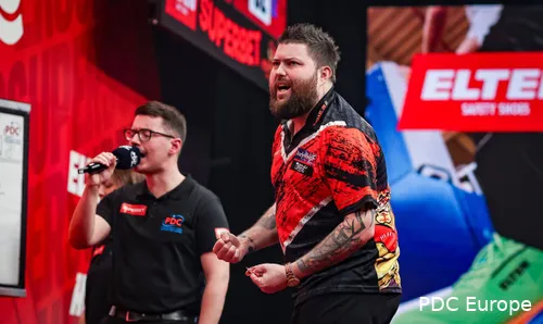 Michael Smith celebrates after winning a leg