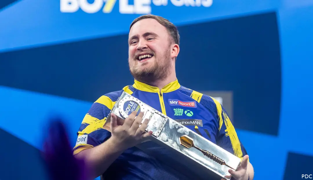 Luke Littler posiert mit der Trophäe.