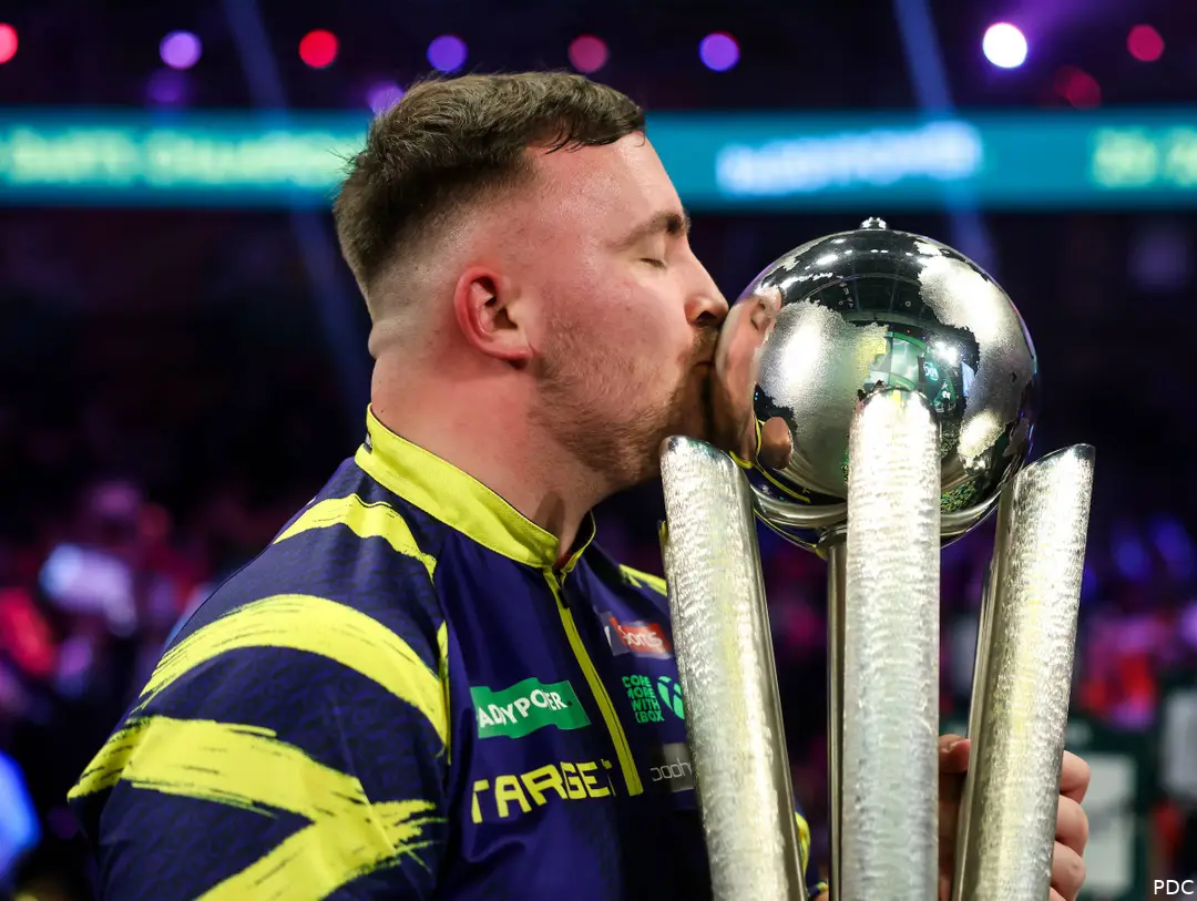 Luke Littler kust de trofee van het WK Darts