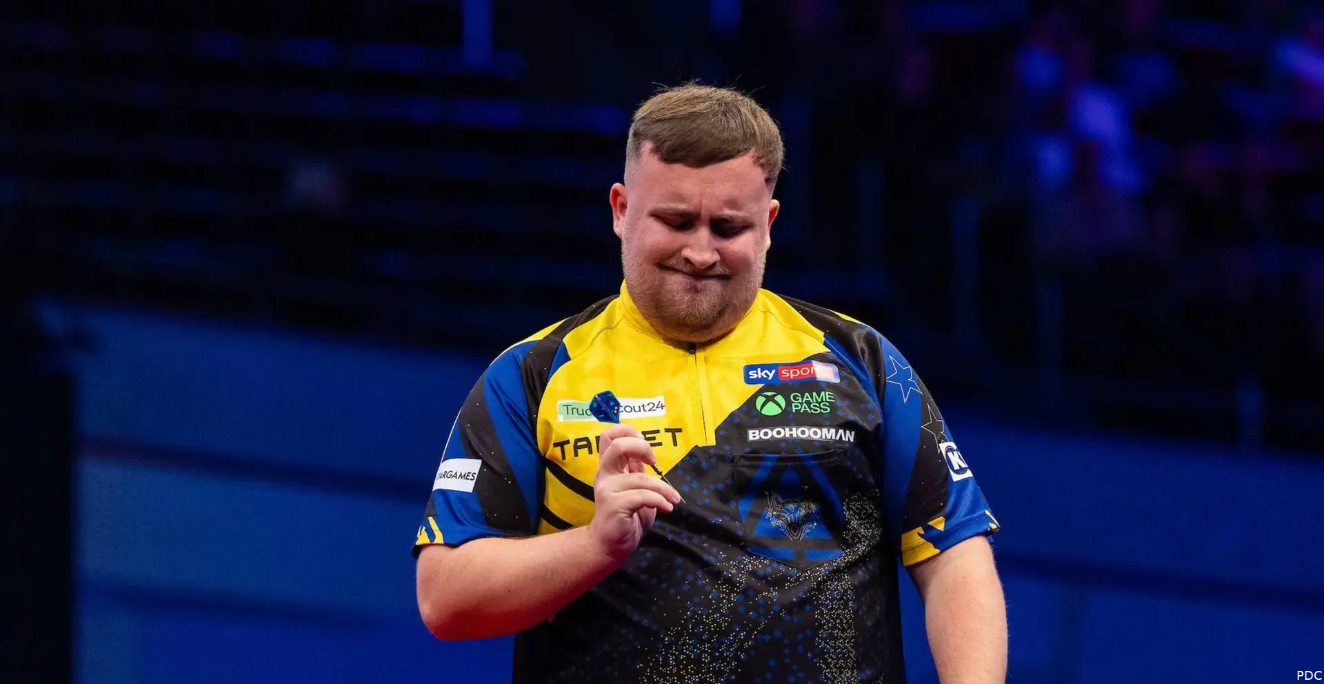 Luke Littler examining dart