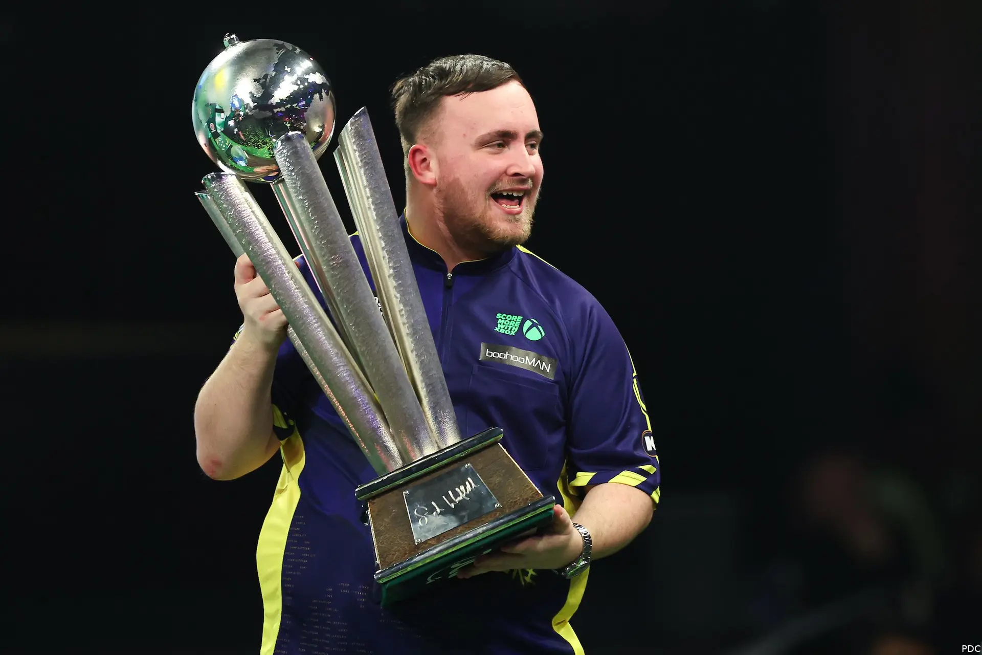 Luke Littler houdt de Sid Waddell Trophy vast
