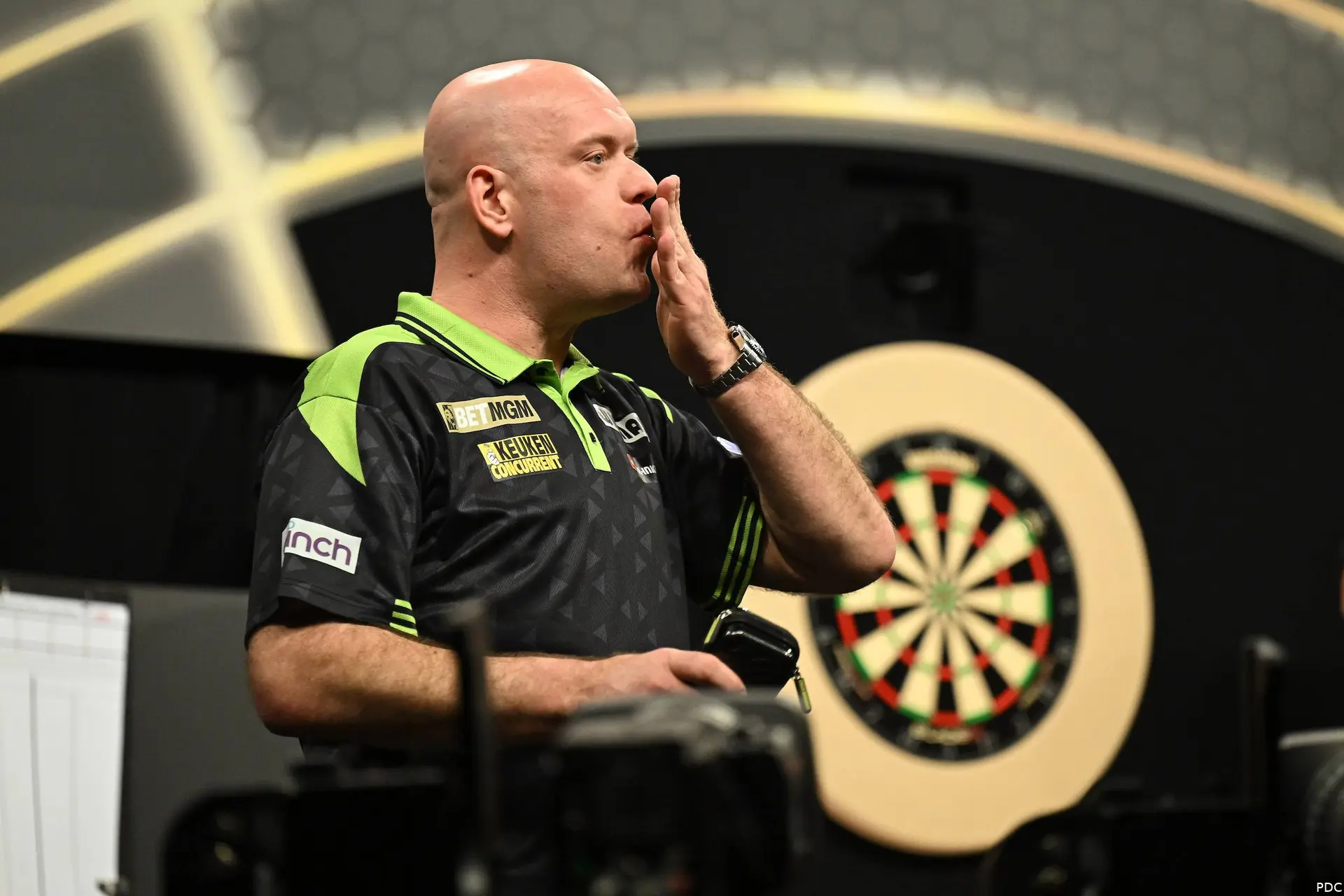 Michael van Gerwen maakt een kusgebaar met zijn hand.