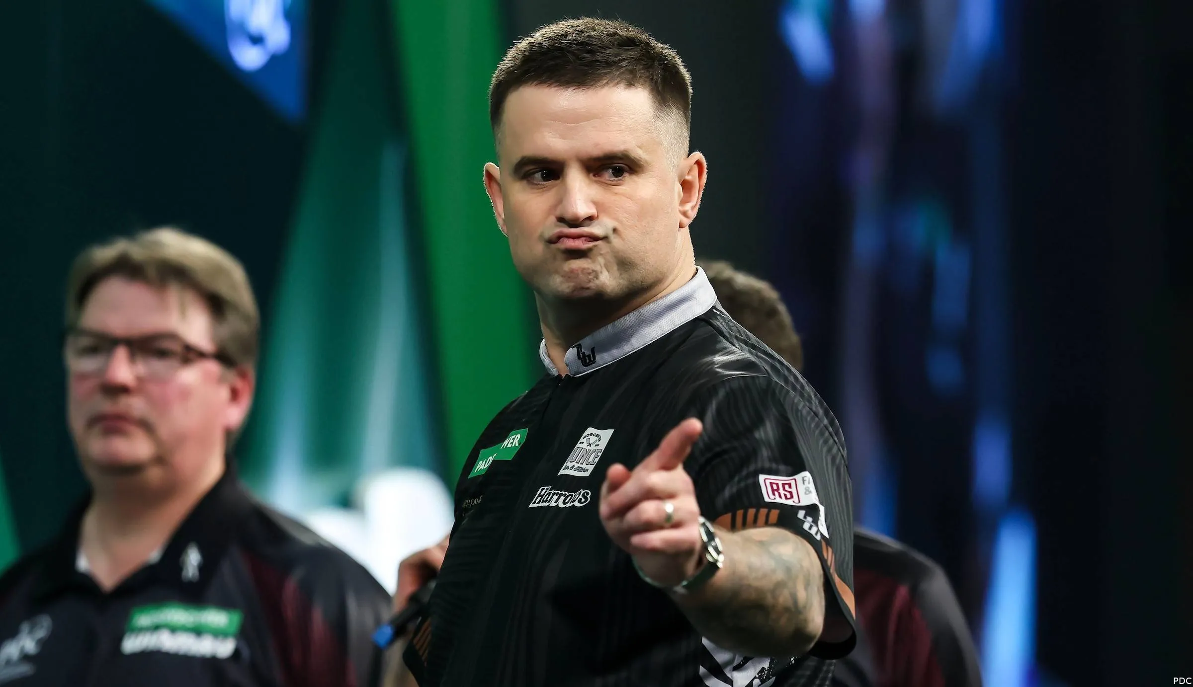 Luke Woodhouse wijst met linker wijsvinger gek gezicht