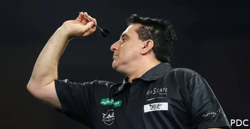 Joe Comito throws a dart at the board.