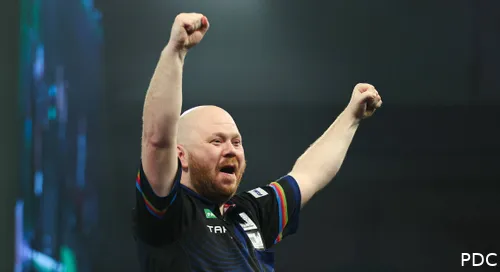 Justin Hood juichend op het podium in Alexandra Palace