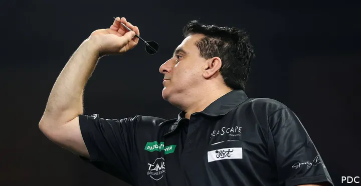 Joe Comito throws a dart at the board.