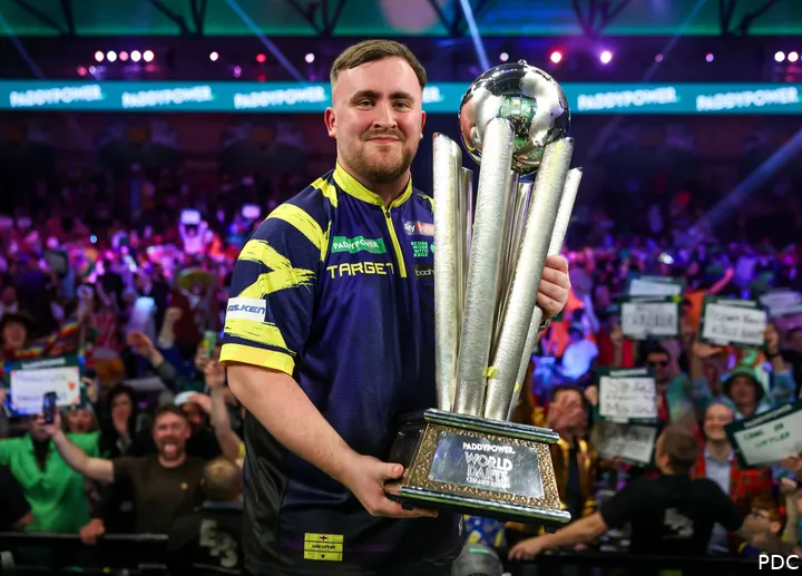 Luke Littler poses proudly with the World Championship trophy