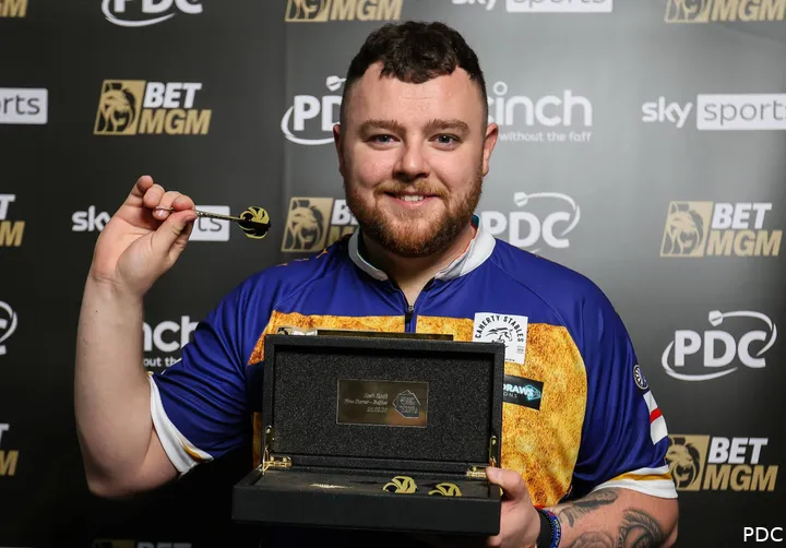 Josh Rock receives his gold darts for hitting a Premier League Darts nine-darter