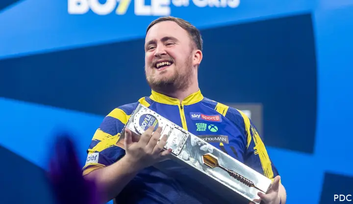 Luke Littler poses with the trophy.