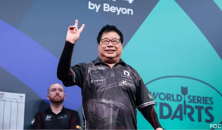 Paul Lim lächelt und zeigt zwei Finger in die Luft.