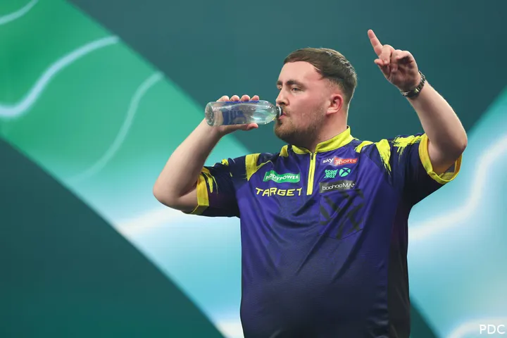 Luke Littler juicht op het podium