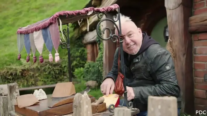 Peter Wright poseert bij één van de Hobbiton-huisjes