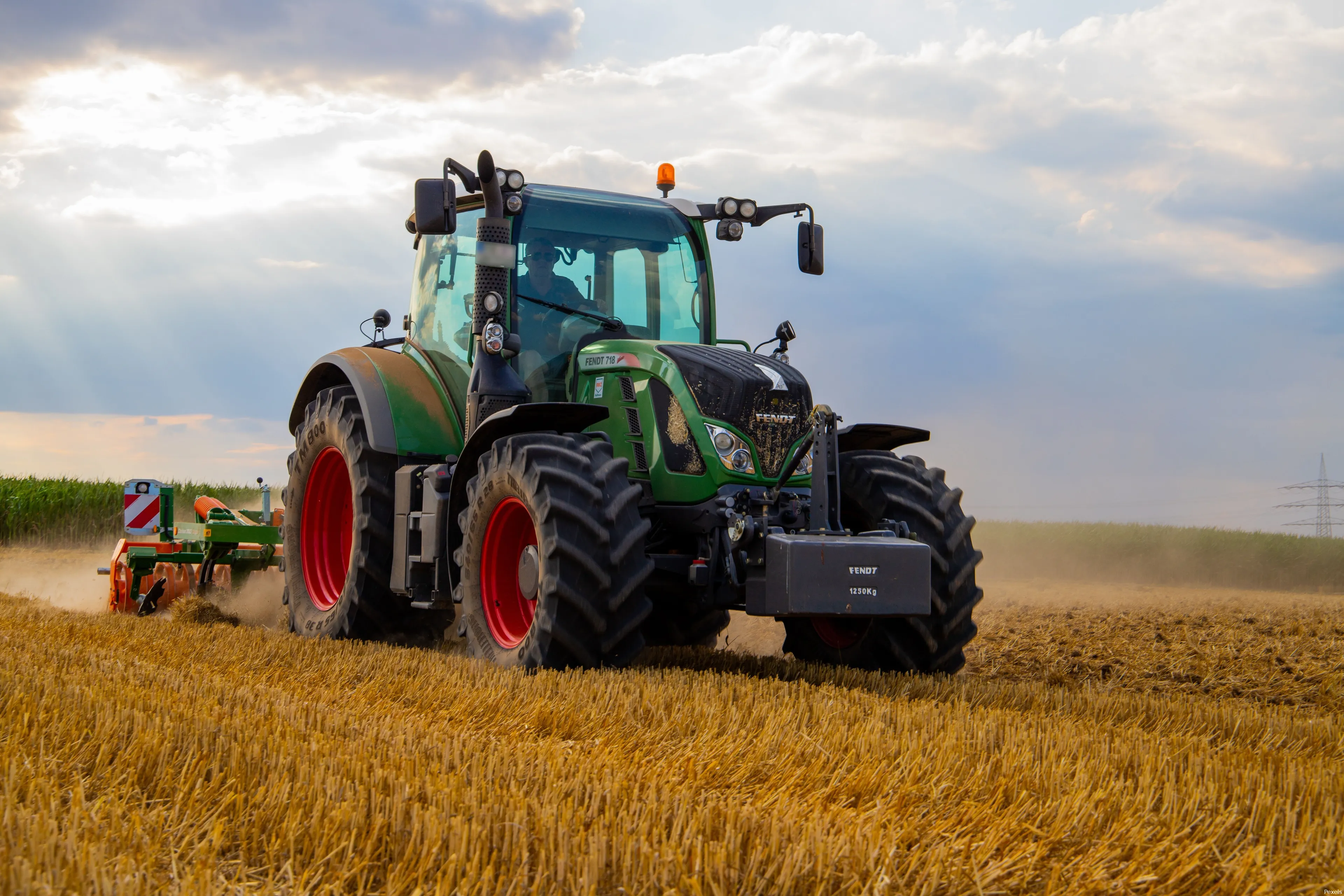 green tractor plowing the fields on focus photography 2933243