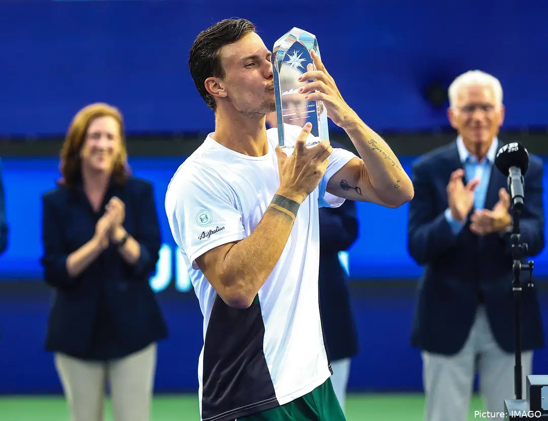 Fucsovics kisses Winston-Salem trophy.