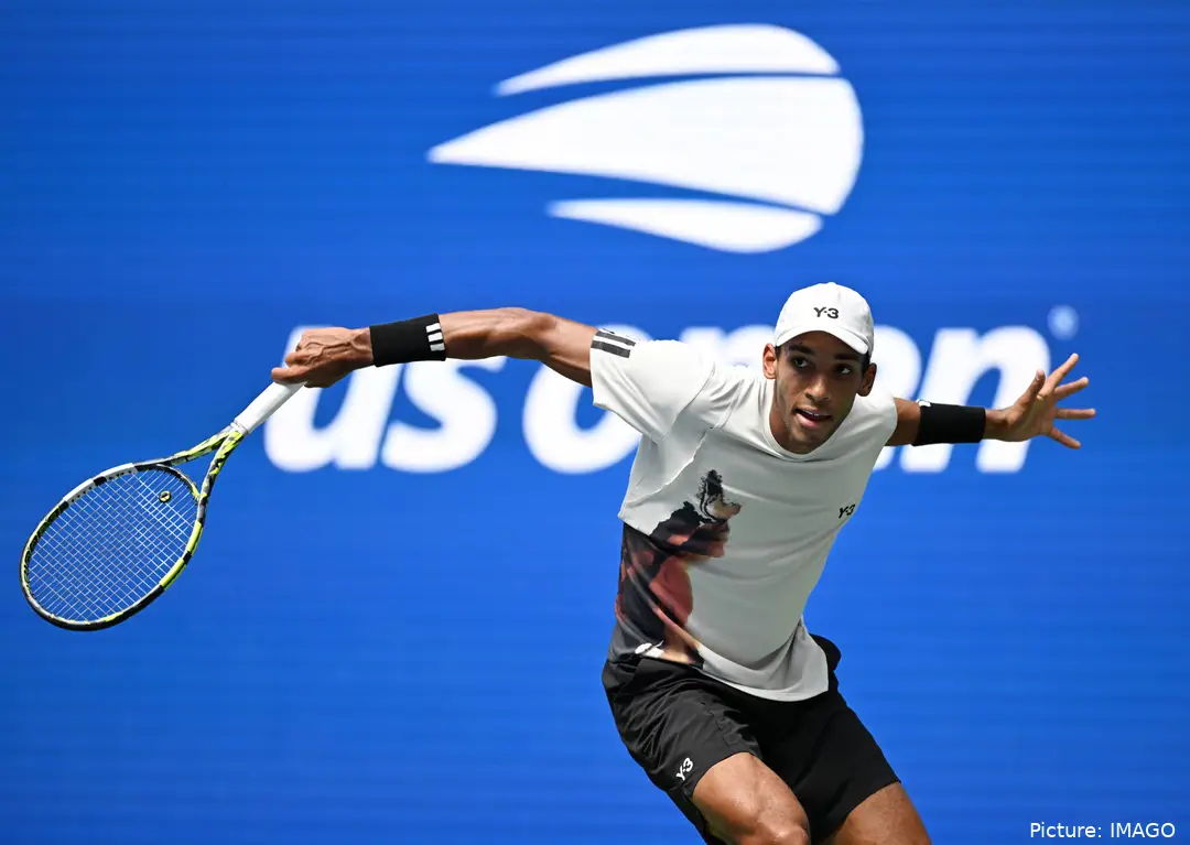 Auger-Aliassime with his right arm outstretched after hitting a slice.