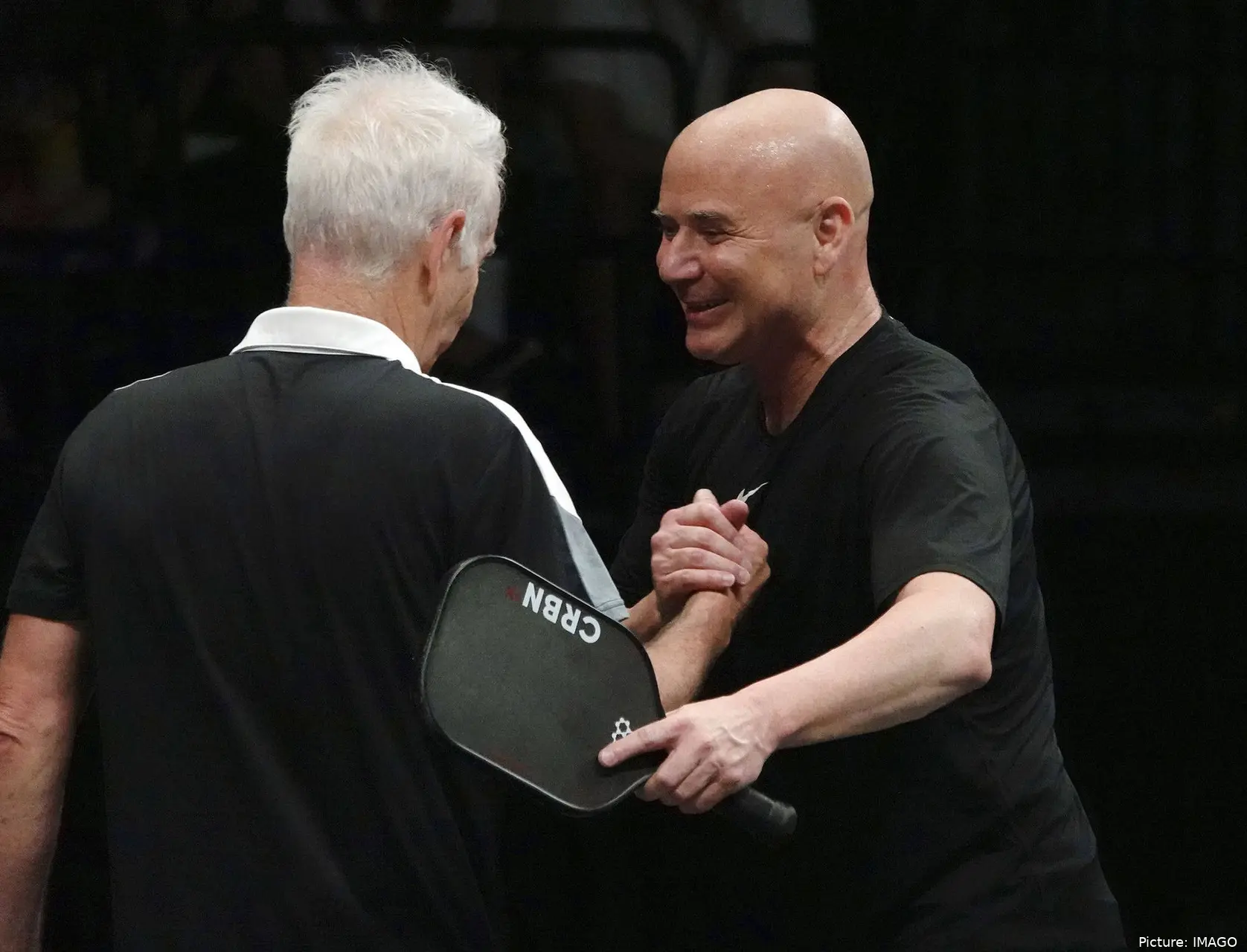 Agassi shaking hands with McEnroe.