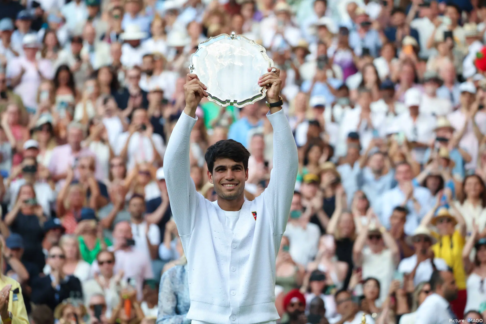 Carlos Alcaaz holding the scale after winning Roland Garros