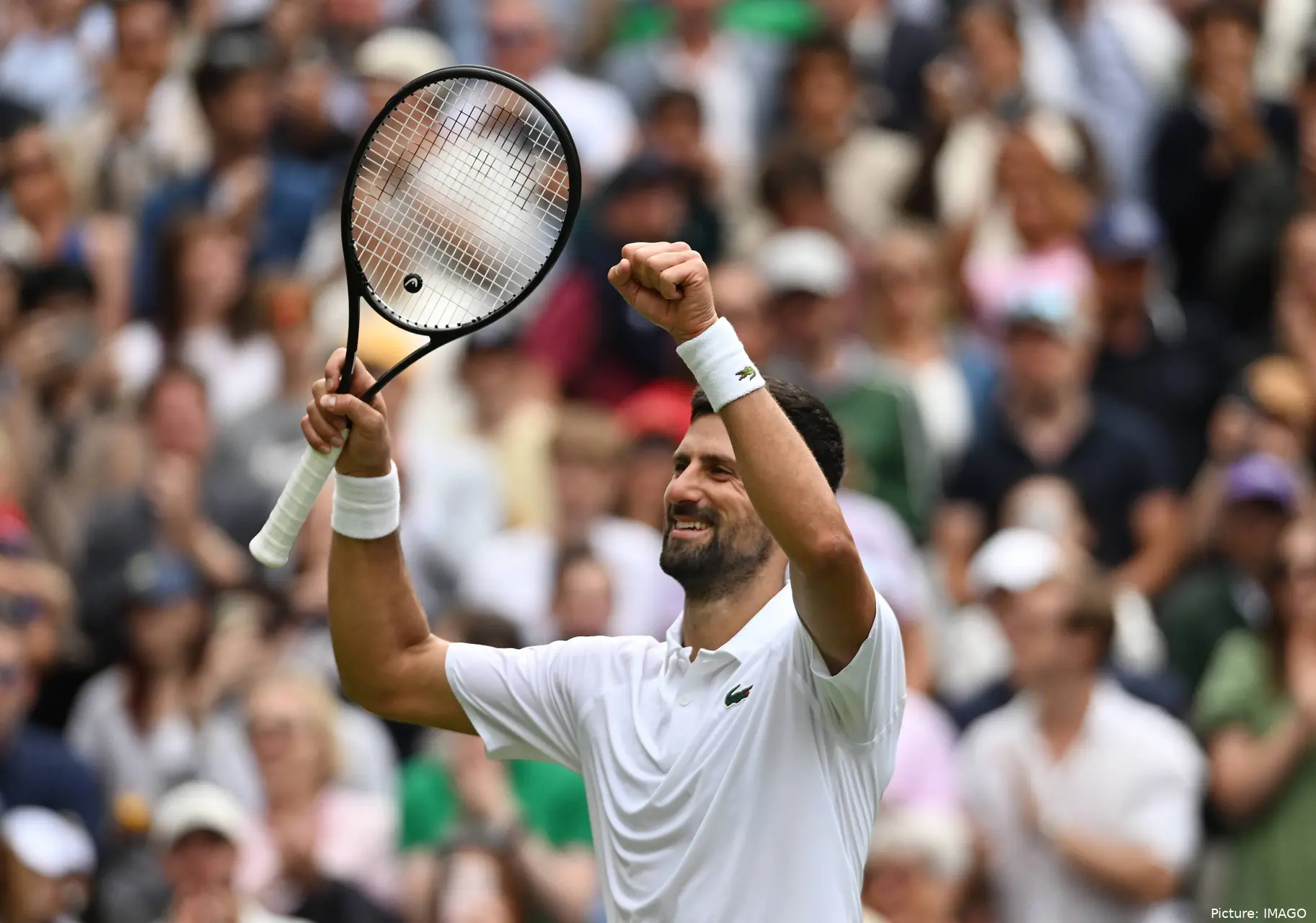 Novak Djokovic at Wimbledon lifting his arms and racket