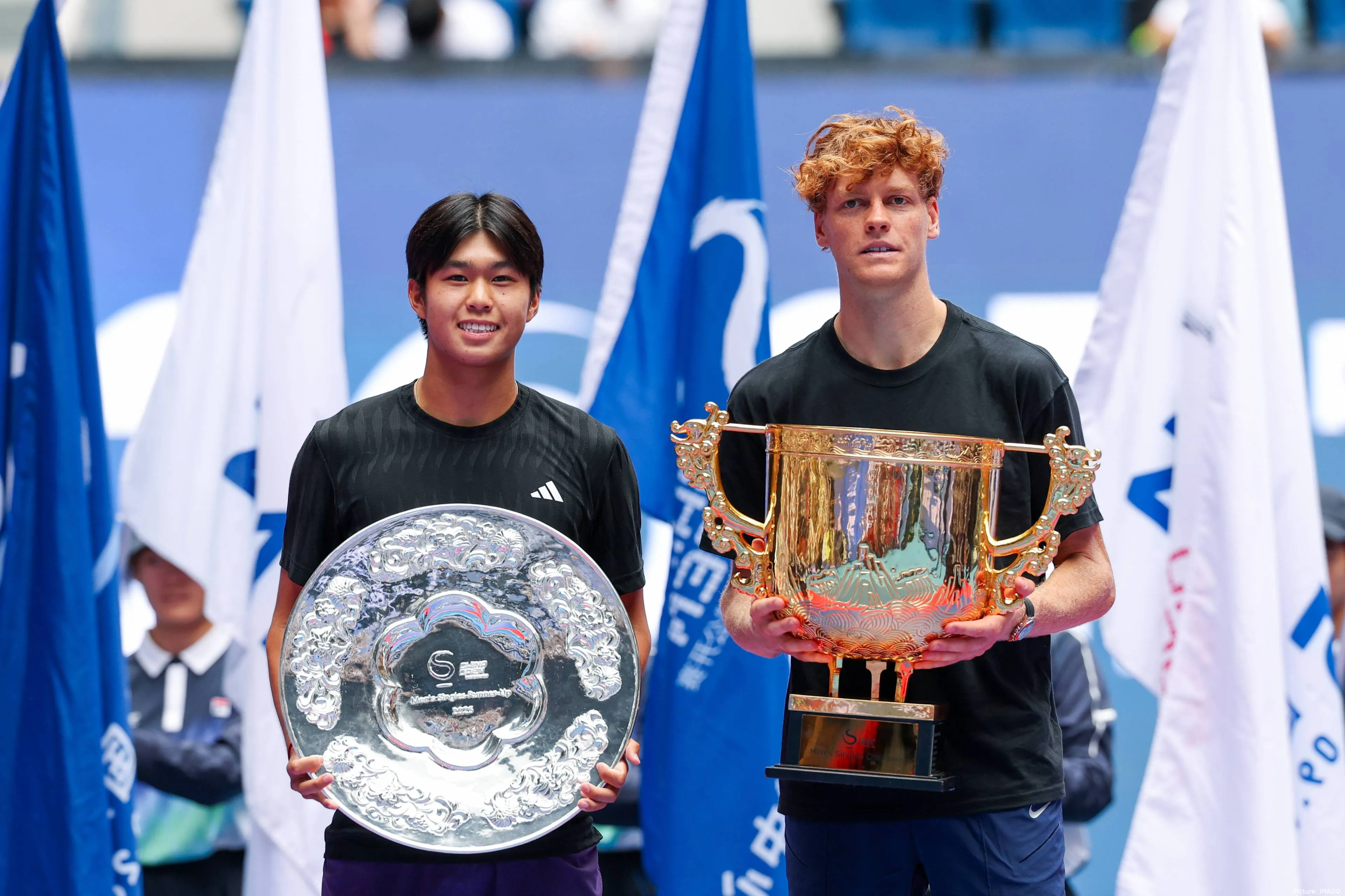 Learner Tien with his runner-up trophy alongside Jannik Sinner.