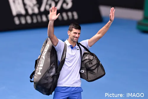Bild Novak Djokovic, Arme erhoben, Taschen um Schultern grüßt Fans&lt;br&gt;