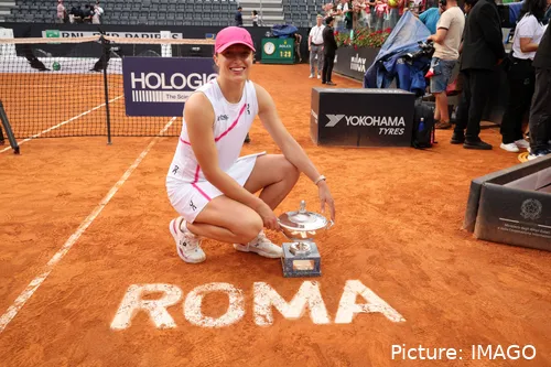 Bild Iga Swiatek in Hockstellung mit Rom Pokal in Nähe des Netzes<br>