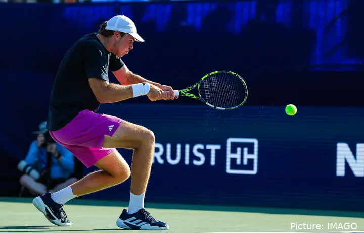 Alex Michelsen hits a two-handed backhand from the baseline