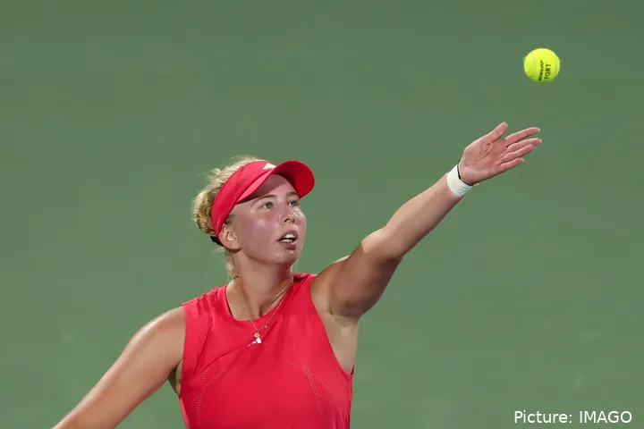 Tauson extends her arm as prepares to serve