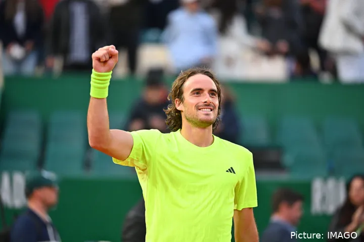 Tsitsipas raises his right arm celebrating a victory in Monte Carlo
