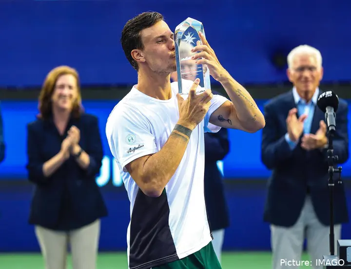 Fucsovics kisses Winston-Salem trophy.