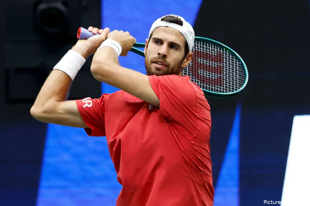 Karen Khachanov with his racket behind his back after hitting a backhand.